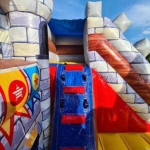 Hüpfburg mit Burgmauern und Rutschen, perfekt für Kinderveranstaltungen, Kindergeburtstage und Events, die sichere und spannende Spielmöglichkeiten bieten.