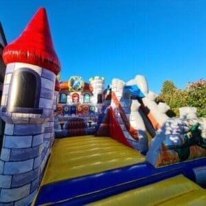 Buntes Hüpfburgen-Spielfeld mit mittelalterlichem Schlossdesign für Kinder, ideal für Kinderfest, Geburtstag oder Veranstaltungen, beworbener Event-Wunsch-Service.